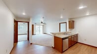Located at 2703 Mayhew Lake Rd NE in Sauk Rapids, Minnesota, this single-floor residence offers a thoughtfully designed layout with a clean, neutral aesthetic throughout. The open-concept main living area seamlessly connects the kitchen and living room, creating a bright and welcoming space. The kitchen features warm medium-toned wood cabinetry, a double-basin sink, a dishwasher, and ample counter space, with a peninsula that defines the transition into the carpeted living area. A ceiling fan and sliding glass door to an outdoor patio add to the comfort and functionality of the living space, which is filled with natural light. The bedrooms are generously sized with plush carpeting, large windows offering exterior views, and well-organized walk-in closets with built-in shelving. Two full bathrooms serve the unit, each featuring a tub-and-shower combination, tile flooring, and clean white fixtures. One bathroom includes a grab bar for added accessibility, while the other offers a warm wood vanity with ample storage and a large mirror. A dedicated in-unit laundry room with hardwood-style flooring houses a full-size washer and dryer, adding everyday convenience. Consistent warm wood trim and light-toned walls carry throughout, creating a cohesive and comfortable living environment.