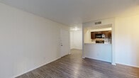 This single-story 2-bedroom, 1-bathroom unit offers a practical and comfortable layout designed for efficient living. The open-concept living room and kitchen area serves as the heart of the home, featuring wood-look luxury vinyl plank flooring that extends throughout the main living spaces, creating a cohesive and modern aesthetic. Neutral-toned walls and a textured ceiling complement the bright, airy atmosphere.

The galley-style kitchen is well-equipped with rich dark espresso cabinetry, black appliances including a range and refrigerator, a stainless steel sink, and a mosaic tile backsplash that adds a decorative touch. A breakfast bar peninsula opens the kitchen toward the living area, enhancing the sense of connectivity.

Both bedrooms are carpeted for comfort, with one featuring a ceiling fan with light fixture and a window that allows natural light. The primary bedroom offers ample space and includes closet access. The full bathroom is clean and functional, featuring a tiled shower-tub combination with chrome fixtures and wood-look flooring. Two closets and a dedicated laundry area round out the unit's storage and utility offerings, making this a highly functional living space.