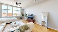 Located at 640 S 50th St in West Des Moines, Iowa, this studio unit offers a thoughtfully designed single-floor layout that maximizes every square foot of its compact footprint. The open living area is bathed in natural light from large windows that frame outdoor views, creating a bright and airy atmosphere. Light-toned hardwood flooring runs throughout, lending warmth and visual continuity across the entire space. A ceiling fan adds both style and function to the main living area. The galley-style kitchen is a standout feature, boasting white cabinetry, granite-style countertops, and stainless steel appliances including a refrigerator, electric range with over-the-range microwave, and dishwasher. A peninsula with additional counter space provides a natural division between the kitchen and the living area, offering extra prep space and informal seating. The bathroom is clean and functional, featuring a vanity with matching granite-style countertop, white cabinetry, a large mirror, and updated fixtures. The hallway connects the spaces efficiently, contributing to the unit's well-organized flow. Neutral gray walls throughout provide a versatile backdrop, making this studio a practical and comfortable living space in a convenient West Des Moines location.