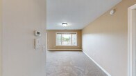 Located at 3705 S Broadway St in Alexandria, Minnesota, this single-floor, 3-bedroom, 2-bathroom unit offers a well-organized layout across a comfortable footprint. The kitchen is a functional centerpiece, featuring warm honey-toned oak cabinetry, a peninsula with double sink, recessed lighting, and white appliances including a range, microwave, and refrigerator. Stone-look tile flooring extends through the kitchen and both bathrooms, adding durability and a cohesive aesthetic. Both bathrooms are outfitted with matching warm wood vanities, light countertops, large mirrors, and oil-rubbed bronze fixtures, lending a consistent, classic style throughout. The three bedrooms are carpeted in neutral tones with clean white walls and trim, providing a bright and versatile canvas. The generously sized primary bedroom includes a wide double-door closet and is the largest of the three rooms. The two additional bedrooms each feature windows that bring in natural light and views of the surrounding exterior. White six-panel doors are used consistently throughout the unit, reinforcing a tidy, uniform interior design. The overall ambiance of the space is clean, neutral, and move-in ready, well suited for comfortable everyday living in a quiet Alexandria community.