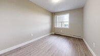 Located at 190 Cherryhill Cir in London, Ontario, this one-bedroom, one-bathroom unit offers a well-organized, efficient layout across a single floor. Light-toned laminate wood flooring runs throughout the space, lending a clean and cohesive aesthetic to every room.

The living room is an open, neutral-toned area featuring a pass-through kitchen counter, providing a functional connection to the kitchen equipped with white appliances. The space benefits from natural light and flows smoothly from the entrance hallway.

The bedroom is a comfortable, well-proportioned room featuring large windows that invite ample natural light and outdoor views of the surrounding landscape. A sliding glass door provides direct access to the private balcony, where elevated views of the greenery below can be enjoyed. Baseboard heating is present throughout the unit.

The bathroom is finished with warm beige tile surrounding a full soaker tub and shower combination with a handheld showerhead. White cabinetry with ample storage sits above the toilet, while a white vanity with an integrated sink and a large mirror completes the space. Wood-look flooring ties the bathroom into the overall design of the unit.

Overall, the unit presents a bright, neutral palette with practical finishes suited for comfortable everyday living.