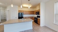 Located at 670 Fitzwater St in Salisbury, Maryland, this single-floor residence offers a well-organized layout with two bedrooms and two full bathrooms. The kitchen is a standout feature, equipped with warm honey-toned cabinetry, granite-style countertops, black appliances including a range, built-in microwave, and refrigerator, and a central island with a sink and pendant lighting overhead. Light hardwood-style flooring runs throughout the main living areas, adding a clean, cohesive look. The combined kitchen and dining area provides a practical and open space for daily living. Both bedrooms are carpeted and generously proportioned, with large windows fitted with blinds that allow ample natural light. The primary bedroom offers notable space and closet storage. The second bedroom also benefits from corner windows, enhancing brightness. Both bathrooms feature warm earth-toned tile flooring, warm wood vanity cabinetry with white countertops, and clean white walls. One bathroom includes a shower-tub combination. A central hallway connects the main rooms, maintaining a logical and efficient flow throughout the residence. The overall aesthetic is neutral and move-in ready, with a bright, clean interior throughout.