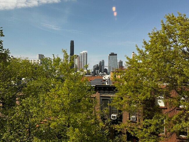 View of brownstone neighborhood, treetops, Brooklyn skylinefrom Bedroom - 682 President St Apartments