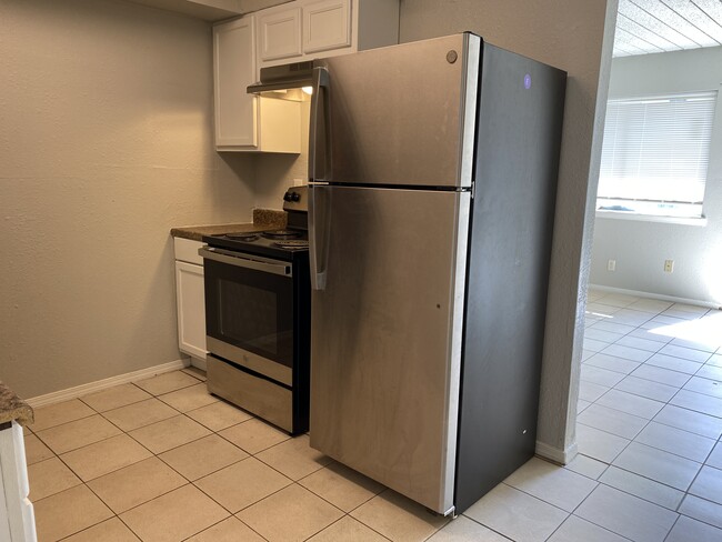 Kitchen features new stainless steel appliances, tile flooring & granite countertops. - Midtown Park Apartments