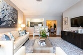 This single-story home in Macon, Georgia offers a thoughtfully designed interior with a cohesive neutral color palette and a blend of hardwood-look flooring and plush carpeting throughout. The open-concept living and dining area serves as the heart of the home, where the living room flows seamlessly into an adjacent sunlit sitting room, both bathed in natural light from large windows with blinds and decorative drapery. A ceiling fan overhead and warm ambient lighting contribute to the comfortable, welcoming atmosphere.

The kitchen features dark cabinetry with ample storage, dark countertops, stainless steel appliances, and wood-look vinyl flooring. A doorway off the kitchen leads directly to an in-unit laundry area, adding everyday convenience. A hallway with the same wood-look flooring connects the main living spaces to the bedrooms and bathrooms.

The primary bedroom is generously sized with plush carpet, a ceiling fan, and windows that bring in natural light. Additional bedrooms offer similar carpeted comfort, natural light, and ample space. The bathroom features dark cabinetry, a well-lit vanity mirror, and wood-look flooring, maintaining the home's consistent design language throughout.