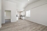 This single-story home in Idaho Falls, Idaho offers a thoughtfully designed floor plan with two bedrooms, one bathroom, and a generous overall footprint. The open-concept living and kitchen area forms the heart of the home, where vaulted ceilings amplify the sense of space and light-toned luxury vinyl plank flooring flows throughout. Natural light pours in through multiple windows, creating a bright and welcoming atmosphere.

The kitchen is well-appointed with white shaker-style cabinetry, dark countertops, stainless steel appliances including a range, microwave, refrigerator, and dishwasher, along with a pantry for additional storage. A door from the kitchen provides direct access to the exterior.

The spacious primary bedroom features vaulted ceilings and a double-door closet, while the second bedroom offers a comfortable layout with a large window overlooking the yard. Three closets total provide ample storage throughout the home. The bathroom includes a full tub/shower combo with clean white surrounds.

Externally, the home showcases a modern gray board-and-batten exterior with well-maintained green lawns on multiple sides. The surrounding neighborhood features a quiet, newly developed streetscape with open views and a concrete driveway, completing this move-in-ready Idaho Falls residence.