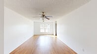 Located at 4963 Raleigh St in Orlando, Florida, this single-story, 3-bedroom, 2-bathroom home offers a practical and comfortable layout with consistent design throughout. The combined living and dining area serves as the heart of the home, featuring warm wood-look flooring, a textured ceiling, a ceiling fan with light fixture, and a window that brings in natural light. The kitchen is equipped with warm-toned wood cabinetry, white countertops, a black electric range, and additional counter space, providing ample room for meal preparation. Each of the three bedrooms features the same wood-look flooring and textured ceilings, with windows offering views of the surrounding neighborhood. The primary bedroom is generously sized and includes a ceiling fan. Multiple bedrooms include sliding-door closets, and the home features a total of six closets, ensuring excellent storage capacity. The two bathrooms differ in configuration: one includes a tiled walk-in shower with a window for natural light and white tile flooring, while the second features a tub-shower combination with white tile surround, a wood-toned vanity, and hardwood flooring. A dedicated laundry area and utility room add further functionality. The home's clean, neutral palette and wood flooring create a bright, cohesive atmosphere throughout.