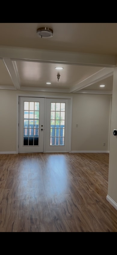 Spacious living room with fireplace, balcony access, wood-style floors, and abundant natural light. - 328 N Allen St