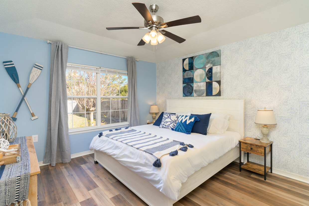 A king-size bed with A 55" Roku TV, a ceiling fan, 2 lamps, nightstands. - 6464 Starfish Cv