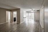 This single-floor, 2-bedroom, 4-bathroom residence is designed with functionality and comfort in mind. The open living area features light wood-style flooring, warm neutral wall tones, and a textured ceiling with a ceiling fan, creating an inviting atmosphere. Vertical blinds allow for adjustable natural light throughout the main living space. The kitchen is well-equipped with white shaker-style cabinetry featuring brushed nickel hardware, granite-style countertops, a stainless steel sink, and a gas range. A breakfast bar connects the kitchen to the living area, offering additional workspace and casual dining. Both bedrooms are carpeted and receive natural light through windows fitted with vertical blinds. The primary bedroom offers a comfortable footprint with dedicated closet space. The bathrooms are finished consistently with white vanities, granite-style countertop surfaces, framed mirrors, and light wood-style flooring. Bathtub and shower combinations are present in the bathrooms, providing practical amenities. The overall color palette of warm beige and white throughout the space creates a cohesive, clean aesthetic that is both neutral and welcoming.