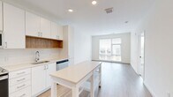 Located at 1245 N Fayette St in Alexandria, VA, this thoughtfully designed one-bedroom, one-bathroom unit offers a bright and contemporary living experience. The open-concept kitchen and living area serves as the heart of the home, featuring light wood-style flooring, recessed lighting, and a large picture window that floods the space with natural light and frames views of the surrounding cityscape.

The kitchen is well-appointed with crisp white cabinetry, stainless steel appliances including a refrigerator, range, microwave, and dishwasher, complemented by a clean white countertop and a subway tile backsplash with warm wood accent shelving. A freestanding kitchen island provides additional prep and dining space, enhancing the room's functionality.

The bedroom is comfortably sized, offering generous natural light through large windows with horizontal blinds overlooking the neighborhood. Light-toned flooring continues throughout, maintaining a cohesive, airy aesthetic. The unit also features an impressive five closets, providing exceptional storage throughout.

The bathroom and additional closet spaces are neatly arranged, contributing to an efficient and well-organized floor plan. The overall design is clean, modern, and move-in ready, making this unit a practical and attractive option in the heart of Alexandria.
