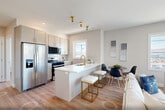 Located at 319 Pennsylvania Ave in Paterson, NJ, this well-appointed 2-bedroom, 2-bathroom residence offers a thoughtfully designed single-floor layout that maximizes comfort and functionality. The open-concept kitchen and living area serves as the heart of the home, where a striking quartz waterfall island with a gold-tone faucet anchors the kitchen. Soft gray cabinetry, a subway tile backsplash, and stainless steel appliances — including a gas range and French door refrigerator — complete the modern aesthetic. The living area is bathed in natural light through oversized windows, offering views of the surrounding neighborhood and creating an airy, welcoming atmosphere. Warm hardwood-style flooring flows throughout the space. The spacious primary bedroom provides a serene retreat, while the second bedroom features a large window that fills the room with daylight. Both bathrooms are finished with clean, contemporary details, including wood-tone vanities with gray countertops and a full tiled tub-shower combo with sliding glass doors. Five closets offer generous storage throughout, and a dedicated laundry area adds everyday convenience. The neutral color palette and modern finishes give the entire residence a cohesive, move-in-ready appeal.