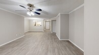 This single-floor, 3-bedroom, 2-bathroom home in Columbus, GA offers a thoughtfully designed layout with a clean, neutral aesthetic throughout. The open living room is a standout space, featuring light wood-style flooring, crown molding, a textured ceiling, and a ceiling fan with integrated lighting. Natural light filters in through multiple windows, and a door provides access to an outdoor area. The galley-style kitchen is efficiently designed with two-tone cabinetry — white upper cabinets and gray lower cabinets — paired with light quartz-style countertops, wood-look tile flooring, a stainless steel refrigerator, and black appliances including an electric range and dishwasher. The spacious primary bedroom offers plush carpeting, a ceiling fan, a louvered closet door, and a window for natural light. The additional two bedrooms are similarly finished with carpet flooring and ceiling fans. The primary bathroom features a dual-sink vanity with white cabinetry, light countertops, a tub/shower combo, and wood-look tile floors. The second bathroom mirrors the same clean, neutral design. Four closets are distributed throughout the home, providing ample storage. The overall palette of warm beiges and soft grays creates a cohesive and inviting atmosphere.
