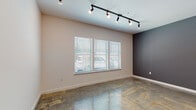This one-bedroom, one-bathroom residence at The Delta in Memphis, Tennessee combines modern urban design with industrial-inspired details throughout its single-story layout. The living area is a standout feature, showcasing polished concrete floors that extend throughout the entire unit, lending the space a sleek, loft-like aesthetic. Track lighting runs along the ceiling, providing both ambient and directed illumination, while an exposed metal ductwork element adds an industrial character to the open living and dining area. A large set of windows fitted with white blinds allows natural light to fill the main living space, complementing the neutral wall tones and a bold charcoal accent wall that adds visual depth.

The kitchen is outfitted with rich, dark wood cabinetry, granite countertops, and stainless steel appliances, including a range and over-the-range microwave. A peninsula counter connects the kitchen to the main living area, enhancing the open-concept flow of the space.

The bathroom is clean and functional, featuring a granite-topped vanity with dark wood cabinetry, a full tub-shower combination, and brushed nickel fixtures. The consistent use of polished concrete flooring carries into the bathroom, maintaining a cohesive design throughout the unit.