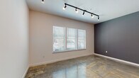 This one-bedroom, one-bathroom residence at The Delta in Memphis, Tennessee combines modern urban design with industrial-inspired details throughout its single-story layout. The living area is a standout feature, showcasing polished concrete floors that extend throughout the entire unit, lending the space a sleek, loft-like aesthetic. Track lighting runs along the ceiling, providing both ambient and directed illumination, while an exposed metal ductwork element adds an industrial character to the open living and dining area. A large set of windows fitted with white blinds allows natural light to fill the main living space, complementing the neutral wall tones and a bold charcoal accent wall that adds visual depth.

The kitchen is outfitted with rich, dark wood cabinetry, granite countertops, and stainless steel appliances, including a range and over-the-range microwave. A peninsula counter connects the kitchen to the main living area, enhancing the open-concept flow of the space.

The bathroom is clean and functional, featuring a granite-topped vanity with dark wood cabinetry, a full tub-shower combination, and brushed nickel fixtures. The consistent use of polished concrete flooring carries into the bathroom, maintaining a cohesive design throughout the unit.