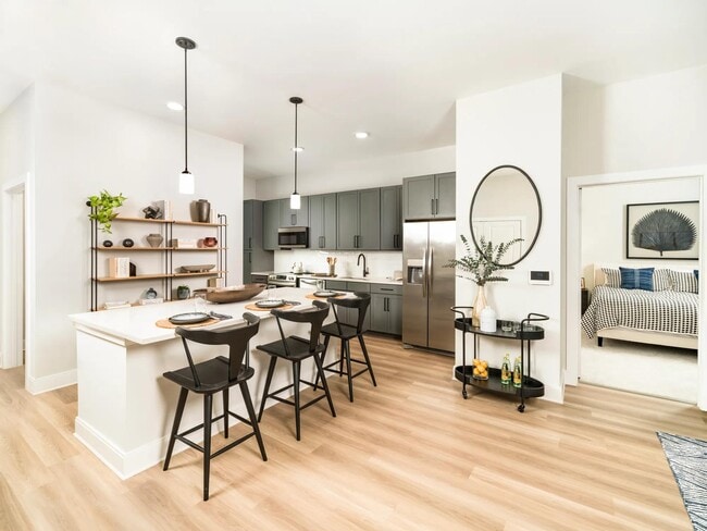 The gourmet kitchens at Modera Liberty Row offer two finish packages, including an option for modern gray cabinetry with black hardware, stainless steel appliances, white quartz countertops, and polished white horizontal tile. - Modera Liberty Row
