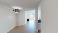 Located at 130 S Alexandria Ave in the Koreatown neighborhood of Los Angeles, this single-floor unit offers a clean, modern living environment with a well-considered layout. The open living and dining area is finished with light wood-style flooring throughout and features a fireplace as a central focal point, complemented by large windows with vertical blinds that invite natural light and provide views to an outdoor balcony area. A textured ceiling and flush-mount lighting complete the bright, airy atmosphere.

The kitchen is thoughtfully designed with white shaker cabinetry, granite-style countertops, a suite of stainless steel appliances including a gas range, over-the-range microwave, and refrigerator, plus a deep sink with a modern faucet. The peninsula-style counter opens toward the living space, enhancing the sense of connectivity.

The bedrooms are generously sized with light wood flooring, textured ceilings, and closet access. Two bathrooms serve the unit: one features a granite-top vanity and a glass-door walk-in shower, while the second offers a full vanity with dark stone countertop, a tub-shower combination, and a window for natural light. The overall aesthetic is clean and contemporary, making this a functional and well-appointed Los Angeles residence.