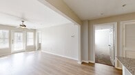 This thoughtfully designed 2-bedroom, 2-bathroom residence offers a comfortable and functional single-floor layout with a clean, modern aesthetic. The open living area features light wood-style flooring, vaulted architectural details, and a ceiling fan, creating an airy, relaxed atmosphere. Natural light streams in through large windows and glass French doors, which lead to an outdoor area and enhance the sense of openness throughout the main living space.

The kitchen is well-equipped with white shaker-style cabinetry, granite-look countertops, stainless steel appliances, a built-in microwave, and a dishwasher. The light wood flooring continues seamlessly through this space, complementing the crisp white finishes.

Both bedrooms are carpeted for comfort and feature ceiling fans and ample natural light. The spacious primary bedroom includes a dedicated closet, while the second bedroom also offers closet access and a bright window. Each of the two bathrooms is finished with white cabinetry, granite-topped vanities, and wood-style flooring, providing a clean and polished look. Upper cabinets in the bathrooms offer additional storage. The residence also includes a utility room and two closets, ensuring practical storage throughout.