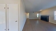 This 630 square foot apartment in Carrollton, Texas offers a well-designed living space with modern amenities. The single-floor layout comprises one bedroom, one bathroom, a living room, and a hallway, creating an efficient and comfortable living environment.

The 140 square foot primary bedroom is spacious for the apartment's size, featuring a large window that allows natural light to flood the room. A walk-in closet with built-in shelving provides ample storage space. The bathroom showcases clean, white tiling and a bathtub-shower combination, offering both functionality and style.

The heart of the apartment is the open-concept living area, which includes a cozy fireplace as a focal point. Large windows in this space offer views of the surrounding area and fill the room with natural light. The entire apartment boasts sleek, wood-look flooring throughout, creating a cohesive and contemporary feel.

The apartment's neutral color palette, with light gray walls and white trim, provides a blank canvas for personal decorating styles. Recessed lighting and crown molding add refined touches to the overall design. The efficient layout maximizes the use of space, making this compact apartment feel larger than its square footage suggests.
