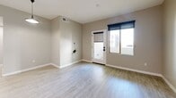 Located in Mesa, AZ, this well-designed 2-bedroom, 2-bathroom residence offers a clean, modern aesthetic across a single floor. The open-concept kitchen and living area serves as the heart of the home, featuring crisp white shaker cabinetry, dark granite countertops, a center island with an integrated sink, black appliances, and stylish pendant lighting — all set atop light wood-look flooring that flows throughout the entire unit. Natural light fills the living area through large windows equipped with roller shades, with a glass door providing access to an outdoor space. Both bedrooms are comfortably proportioned, bathed in natural light from sizeable windows, and finished with the same neutral, warm-toned walls and light flooring. The primary bedroom includes a sliding closet for added storage. Each bathroom is finished consistently, featuring a tub-shower combination with white subway tile surround, dark matte hardware accents, light wood-look tile flooring, and a dark-toned vanity with granite countertops. A hallway connects the bedrooms and bathrooms efficiently. The overall ambiance is bright, neutral, and move-in ready, with a cohesive modern design throughout.