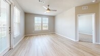 Located in Richmond, TX, this single-floor 2-bedroom, 2-bathroom residence offers a thoughtfully designed layout with modern finishes throughout. The open-concept kitchen and living area serves as the heart of the home, showcasing a large granite-topped island with pendant lighting, stainless steel appliances, and crisp white cabinetry complemented by dark accent cabinets. Light wood-tone flooring flows seamlessly through the main living areas, creating a bright and cohesive aesthetic.

Both bedrooms are well-proportioned and filled with natural light from dual windows fitted with blinds. Ceiling fans provide comfort in each room, while soft carpet underfoot adds warmth. Each bedroom is paired with its own dedicated closet, both outfitted with built-in shelving and hanging rods for efficient storage.

The primary bathroom is especially spacious, featuring a dual-sink granite vanity with gray cabinetry, framed mirrors, and light wood flooring. The second bathroom offers a similarly refined look with a single granite vanity and a tall storage cabinet. Both bathrooms are finished with polished chrome fixtures for a clean, contemporary feel.

The neutral warm-gray color palette used throughout the residence creates a calm, cohesive ambiance, making every room feel inviting and move-in ready.
