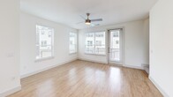 Located at 1100 Corinth St in Dallas, TX, this contemporary three-story townhome offers a thoughtfully designed layout spread across three distinct levels. The ground floor houses an attached garage with an automatic opener, electrical panel, and water heater — providing secure parking and convenient utility access directly from the interior entry hallway, which also features a double-door closet for added storage.

The main living level showcases an open-concept kitchen and living room bathed in natural light from multiple windows with neighborhood views. The kitchen is outfitted with sleek gray cabinetry, white quartz countertops, a tile backsplash, stainless steel appliances including a French door refrigerator, and a center island. Light wood-look flooring flows throughout, complemented by a ceiling fan overhead.

The upper floor is dedicated to the private bedroom suite, which is generously sized and features plush carpeting, multiple windows that invite abundant natural light, and a ceiling fan. The full bathroom is elegantly appointed with a dual-sink vanity topped with white quartz, gray cabinetry with matte black hardware, a large mirror with vanity lighting, wood-look flooring, and a tiled walk-in shower. A dedicated closet completes the top floor. The exterior presents a clean modern farmhouse aesthetic with board-and-batten siding and a gabled roofline.