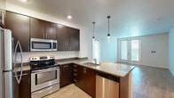This well-designed 2-bedroom, 2-bathroom residence at 28850 Dixon St in Hayward, California offers a thoughtfully laid-out single-level floor plan. The open-concept kitchen and living area serves as the heart of the home, featuring rich dark-brown cabinetry, stainless steel appliances including a refrigerator, range, and microwave, sleek gray countertops, a peninsula with pendant lighting, and durable wood-style flooring. Natural light filters into the living area through a sliding glass door that opens to a balcony with views of surrounding greenery.

Both bedrooms are carpeted and generously sized, offering a quiet retreat. The primary bedroom is particularly spacious and includes a large walk-in closet with wrap-around hanging rods. The second bedroom benefits from a bright window with outdoor views. Each bathroom is finished consistently with wood-style tile flooring, dark-cabinetry vanities, gray countertops, large mirrors, and well-lit fixtures. One bathroom features a full tub-shower combination, while the second offers a clean, functional layout. A connecting hallway with additional closet storage ties the space together efficiently, creating a cohesive and comfortable living environment.