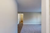 Located at 203 Eastdale Rd S in Montgomery, Alabama, this single-story, one-bedroom, one-bathroom unit offers a well-organized layout designed to maximize every square foot. The combined living and dining area is a comfortable, open space finished with soft gray carpeting and neutral-toned walls, with French doors that invite natural light and provide access to the outdoors. A hallway connects the main living areas to the private quarters, maintaining a clear and functional flow throughout. The galley-style kitchen is outfitted with white shaker cabinetry, light granite-style countertops, a stainless steel sink, and wood-look flooring, creating a clean and practical cooking space. The bedroom offers plush carpeting, a ceiling fan with light fixture, a sliding-door closet, and a window that brings in natural light and exterior views. Three closets throughout the unit provide generous storage options. The bathroom features a tiled shower-tub combination with white tile surround and neutral wall tones, keeping the space feeling fresh and functional. Throughout the unit, consistent neutral colors, white trim, and ceiling-mounted ventilation contribute to a cohesive and well-maintained living environment.
