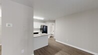Located at 1110 Garden Walk Blvd in Atlanta, GA, this one-bedroom, one-bathroom unit offers a well-organized single-floor layout designed for comfortable everyday living. The open-concept living and kitchen area serves as the heart of the home, where dark hardwood-style flooring extends throughout, complemented by neutral gray walls and crisp white trim. Large vertical blinds line the living area windows, allowing generous natural light to fill the space while a ceiling fan adds a functional touch overhead.

The kitchen is well-appointed with white shaker-style cabinetry, granite-patterned countertops, a tiled backsplash, and black appliances including a range, dishwasher, and refrigerator. A peninsula counter provides additional prep space and creates a natural transition between the kitchen and living area.

The bedroom is generously sized, featuring plush carpeting, a large window with blinds for natural light, and a six-panel door. Two closets provide ample storage throughout the unit. The bathroom includes a full tub-shower combination with white tile surround and brushed nickel fixtures, maintaining the clean and consistent aesthetic found throughout the space.