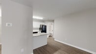 Located at 1110 Garden Walk Blvd in Atlanta, GA, this one-bedroom, one-bathroom unit offers a well-organized single-floor layout designed for comfortable everyday living. The open-concept living and kitchen area serves as the heart of the home, where dark hardwood-style flooring extends throughout, complemented by neutral gray walls and crisp white trim. Large vertical blinds line the living area windows, allowing generous natural light to fill the space while a ceiling fan adds a functional touch overhead.

The kitchen is well-appointed with white shaker-style cabinetry, granite-patterned countertops, a tiled backsplash, and black appliances including a range, dishwasher, and refrigerator. A peninsula counter provides additional prep space and creates a natural transition between the kitchen and living area.

The bedroom is generously sized, featuring plush carpeting, a large window with blinds for natural light, and a six-panel door. Two closets provide ample storage throughout the unit. The bathroom includes a full tub-shower combination with white tile surround and brushed nickel fixtures, maintaining the clean and consistent aesthetic found throughout the space.