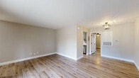 Located at 4162 Treadway Rd in Beaumont, TX, this well-appointed one-bedroom, one-bathroom unit offers a thoughtfully designed single-level layout with modern updates throughout. Light wood-tone flooring flows seamlessly across every room, creating a warm and cohesive aesthetic.

The living room is bright and open, featuring a gold-toned pendant light fixture, neutral walls, and a sliding glass door that opens to a private balcony overlooking a lush green lawn and the surrounding neighborhood. An additional living area near the entry provides flexible space and is illuminated by a classic ceiling-mounted fixture.

The kitchen is efficiently designed in a galley-style layout, outfitted with gray shaker-style cabinetry, matte black hardware, white quartz countertops, and stainless steel appliances including a refrigerator, electric range, and microwave.

The spacious primary bedroom includes a ceiling fan with light kit, a window for natural light, and access to both a dedicated closet and an in-unit washer and dryer area. The bathroom features a full tub-shower combo with a crisp white surround, matte black fixtures, and gray cabinetry for added storage. Clean lines and neutral tones throughout give this unit a fresh, move-in-ready appeal.