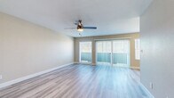 This efficiently designed single-floor residence offers a comfortable and cohesive layout across one bedroom, one bathroom, a kitchen, and a closet. Throughout the space, light-toned luxury vinyl plank flooring creates a clean, modern aesthetic that ties each room together seamlessly.

The open living area is bright and airy, benefiting from a large sliding glass door flanked by vertical blinds and an additional window that invites generous natural light. A ceiling fan with integrated lighting provides both comfort and illumination, making the space feel welcoming and functional.

The galley-style kitchen is thoughtfully appointed with crisp white shaker cabinets, light countertops, recessed lighting, and stainless steel appliances including a refrigerator and dishwasher. The layout maximizes efficiency while maintaining a clean, contemporary look.

The bedroom is a comfortable, well-proportioned room with its own window and ceiling fan, offering natural light and ventilation. Warm neutral walls carry throughout the home, contributing to a calm and cohesive atmosphere.

The bathroom features a full tub-and-shower combination with white tile surround and polished chrome fixtures, maintaining the clean and understated design found throughout the rest of the residence. A dedicated closet completes the layout, adding practical storage to this thoughtfully arranged home.