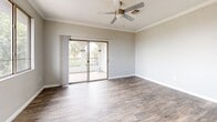 This 2-bedroom, 2-bathroom unit in Goodyear, Arizona presents a well-organized single-level layout designed for functional everyday living. Wood-look plank flooring runs consistently throughout the space, complementing neutral gray walls and crisp white baseboards and trim to create a clean, cohesive aesthetic.

The kitchen is a standout feature, outfitted with warm-toned wood cabinetry, white countertops, and a full suite of stainless steel appliances including an electric range, microwave, dishwasher, and refrigerator. The kitchen opens directly to the living area, which benefits from large windows fitted with vertical blinds that allow natural light to fill the space while offering views of the surrounding Goodyear neighborhood.

Both bedrooms are comfortably proportioned, each featuring windows that bring in natural light. The primary bedroom is notably spacious, with ample room for furnishings. Each bathroom includes a wood-toned vanity with white countertop, a large mirror with overhead lighting, and a tub-shower combination with white tile surround. A hallway connects the main living areas to the bedrooms and bathrooms, with a dedicated closet providing additional storage. The overall ambiance is bright, clean, and move-in ready.