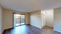 Located at 5669 N Fresno St in Fresno, CA, this one-bedroom, one-bathroom unit offers a practical and well-organized single-story layout. The living room is a bright, open space featuring rich wood-look flooring, neutral beige walls, and a textured ceiling. A sliding glass door fills the room with natural light and provides direct access to a private patio with outdoor views. The combined kitchen and dining area flows seamlessly from the living space. The galley-style kitchen is equipped with white cabinetry, light-toned countertops, a gas range, dishwasher, and refrigerator, all finished with wood-look flooring that continues throughout the common areas. The dining area features a ceiling fan and built-in cabinetry, lending a functional yet cozy atmosphere. The bedroom is carpeted for comfort and includes a ceiling fan with light fixture, a window with outdoor views, and access to two closets for ample storage. The bathroom is clean and simply appointed, with a single-sink vanity with light countertops, a tiled shower-tub combination, and wood-look flooring. Additional utility and hallway spaces complete this efficiently designed unit, ideal for those seeking a straightforward and comfortable living arrangement in Fresno.