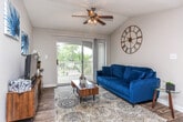Located at 900 Meadow Glen Pkwy in Fairburn, Georgia, this single-floor residence offers a well-designed layout that balances comfort and functionality throughout. The living room is a welcoming space featuring vaulted ceilings, wood-style flooring, and a ceiling fan light fixture. A sliding glass door opens to a private balcony, flooding the room with natural light and offering pleasant outdoor views of surrounding greenery. The kitchen is equipped with white cabinetry, light countertops, and stainless steel appliances including a range and dishwasher, all set over wood-style flooring for a clean, modern look. A dedicated dining area provides an intimate setting beneath a pendant chandelier. The residence includes multiple bedrooms, each carpeted for warmth and comfort, with ceiling fan fixtures and windows that bring in natural light. The primary bedroom is notably spacious. Two bathrooms serve the home, both featuring white vanities with large mirrors, light countertops, and wood-style flooring. One bathroom includes a tub-shower combination, while the other is well-appointed with generous counter space. Textured ceilings are consistent throughout, adding a classic touch to this practical and inviting single-floor home.