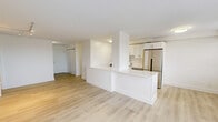 Located at 77 Prospect Street, Unit 8D in Stamford, Connecticut, this two-bedroom, four-bathroom residence offers a clean, modern aesthetic throughout. Light-toned hardwood flooring runs continuously across the single-floor layout, lending warmth and cohesion to every room.

The combined kitchen and living area forms the heart of the home. The kitchen is thoughtfully appointed with white cabinetry, subway tile backsplash, stainless steel appliances including a full-size refrigerator, gas range, microwave, and dishwasher, and a bright white peninsula that separates the cooking space from the open living area. The living room benefits from multiple windows fitted with horizontal blinds, allowing ample natural light, and includes track lighting overhead and direct access to a private balcony.

The generously sized primary bedroom provides a comfortable and airy retreat, complete with a built-in closet. The second bedroom is equally well-proportioned with its own closet storage. Four bathrooms serve the residence, including one featuring classic white subway tile, a soaking tub, a white vanity with gold-tone fixtures, and marble-look tile flooring. Additional bathrooms maintain the same crisp, neutral palette.

The private balcony offers outdoor space with views of the surrounding Stamford cityscape, completing this well-designed urban residence.