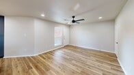 This thoughtfully designed one-bedroom, one-bathroom residence in Greenville, Texas, offers a clean, modern aesthetic with consistent finishes throughout. Warm hardwood-style flooring flows seamlessly across the entire living space, creating a cohesive and inviting atmosphere.

The open-concept kitchen and living area serves as the heart of the home. The kitchen is outfitted with slate-blue shaker cabinetry extending to the ceiling for ample storage, a full suite of stainless steel appliances including a refrigerator, electric range, and over-the-range microwave, and a crisp white quartz countertop with an undermount sink. A large peninsula with pendant lighting connects the kitchen to the living area, making it ideal for both cooking and entertaining. The spacious living room benefits from recessed lighting and a ceiling fan, with a front-facing window that brings in natural light.

The primary bedroom is a comfortable retreat featuring a ceiling fan, recessed lighting, a window with an outdoor view, and a double-door closet providing generous storage. The full bathroom includes a dark-framed glass shower enclosure, white quartz vanity countertop with an undermount sink, matching cabinetry, and wood-look flooring that ties back to the rest of the home.