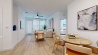 Located in Daytona Beach, FL, this well-designed 2-bedroom, 2-bathroom residence offers a thoughtfully planned single-floor layout that maximizes comfort and functionality. Light wood-look flooring flows seamlessly throughout, complementing the crisp white walls and creating a clean, airy aesthetic.

The open-concept living and dining area is filled with natural light from large windows dressed with sheer curtains and blinds. A ceiling fan adds a practical touch, while French doors lead out to a private balcony. The kitchen is a standout feature, boasting white cabinetry, stainless steel appliances, a subway tile backsplash, and a spacious island with bar seating illuminated by modern pendant lighting — ideal for both cooking and entertaining.

Both bedrooms are comfortably sized, with the primary bedroom offering generous proportions, large windows, and access to a dedicated walk-in closet. Each bathroom is finished with white tile, clean-lined vanities, and glass-enclosed showers. A second walk-in closet provides additional storage throughout the home.

The overall ambiance is bright, modern, and welcoming — a cohesive neutral palette and thoughtful design details make this Daytona Beach residence a comfortable and stylish place to call home.