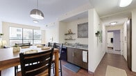This single-floor unit offers a thoughtfully designed layout comprising multiple private bedrooms, a shared kitchen and dining area, and individual bathrooms, as seen in the 3D floor plan. The open-concept kitchen and dining space is anchored by wood-toned cabinetry, granite countertops, and black appliances including an electric range with over-the-range microwave. A pendant light fixture highlights the dining area, while large windows allow natural light to fill the adjoining living space.

Each bedroom features plush carpeted flooring, neutral warm-toned walls, and a generously sized window that invites natural light and outdoor views. The rooms are designed with functionality in mind, offering ample space for sleeping and study areas. Several bedrooms feature direct access to a private bathroom, enhancing privacy within the shared layout.

The bathrooms are consistently finished with wood-look vinyl flooring, granite-topped dark wood vanities, and tiled walk-in showers. Each bathroom also includes a wire-shelved closet for additional storage. The overall aesthetic throughout the unit is clean and modern, with a neutral palette and consistent finishes creating a cohesive, comfortable living environment.