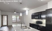 This 610-square-foot, one-bedroom, one-bathroom apartment is located at 650 S Main St, Unit 1111, in Fort Worth, TX 76104. The unit is laid out across a single floor and thoughtfully designed to maximize functionality within its compact footprint. The kitchen is a standout feature, equipped with dark espresso cabinetry, granite countertops, a large center island with a built-in sink and pendant lighting, and stainless steel appliances including a refrigerator, electric range, microwave, and dishwasher. Wood-style luxury vinyl flooring runs throughout the main living areas, lending a clean, contemporary aesthetic. The open living area offers natural light through large windows with blinds and features a ceiling fan, creating a comfortable and airy atmosphere. A private exterior door provides direct access from the living space. The bedroom, spanning 150 square feet, is carpeted for added comfort, includes a ceiling fan, a large window, and direct access to a dedicated walk-in closet with built-in shelving. The bathroom is finished with matching dark cabinetry, a granite vanity top, an overhead cabinet for additional storage, a large mirror, and a full tub-shower combination, all set on wood-style flooring.