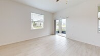 Located at 17224 Auburn Arch Loop in Wimauma, FL, this two-story home offers a clean, modern aesthetic with a bright, neutral palette carried throughout both levels. The ground floor hosts the main living areas, including an open-concept kitchen and living room. The kitchen is a standout feature, outfitted with crisp white shaker cabinetry, a subway tile backsplash, stainless steel appliances, and a central island with an undermount sink — all set atop light-toned tile flooring that extends into the living area. The living room benefits from sliding glass doors that invite natural light and provide outdoor views of the surrounding neighborhood. An attached garage with a dedicated water heater and interior access door completes the lower level. Upstairs, the home's three bedrooms are finished with plush carpet and ceiling fans, each offering natural light through blinds-fitted windows. The spacious primary bedroom provides generous room to furnish comfortably. The bathrooms are finished in a consistent modern style, with the full bath featuring a glass-enclosed walk-in shower with large-format white tile, a white vanity with quartz-style countertop, and light wood-look flooring. Hallways and a dedicated laundry area add practicality to this well-designed home.