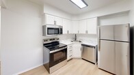 This 630 sq ft, single-floor apartment at 5 Dundas Ct in Parkville, MD offers a clean, modern design throughout. The open living area features light wood-style flooring and bright white walls, with windows providing natural light and outdoor views. The kitchen is well-appointed with white shaker cabinets, marble-style countertops, and stainless steel appliances including a range, microwave, dishwasher, and refrigerator. The 150 sq ft bedroom features plush carpet flooring, a sliding-door closet, and a window with natural light. The bathroom includes a full tub/shower combo, vanity, and wood-style flooring. A dedicated closet completes this efficient, move-in-ready unit.