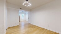 Located at 714 E Linwood Blvd in Kansas City, MO, this efficiently designed 1-bedroom, 1-bathroom unit offers a clean, modern aesthetic throughout its single floor. Light-toned hardwood flooring runs continuously across the living, dining, and bedroom areas, lending a cohesive warmth to the space.

The open living and dining areas are illuminated by a contemporary geometric pendant light fixture and benefit from natural light filtering through multiple windows. The layout flows naturally into a dedicated dining space and toward the kitchen, which is appointed with white shaker-style cabinetry, classic white subway tile backsplash, and a full suite of stainless steel appliances including a refrigerator, electric range, and over-the-range microwave.

The bedroom is a well-proportioned, bright room with its own closet and easy access to the rest of the unit. The bathroom features large-format dark slate wall tiles contrasted by a mosaic marble-style tile floor, a modern vanity with mirror cabinet, and a bathtub with shower. A utility room rounds out the functional spaces. The unit's crisp white walls, updated finishes, and natural light throughout create a clean, move-in-ready living environment.