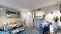 Located at 3223 W Ina Rd in Tucson, Arizona, this efficiently designed one-bedroom, one-bathroom residence offers a well-organized layout across a single floor. The open living room serves as the heart of the home, featuring warm wood-style flooring, a textured ceiling, and a sliding glass door that leads to a private outdoor patio — bringing in natural light and easy access to fresh air. A pass-through counter connects the living area to the kitchen, which is equipped with white cabinetry, granite-style countertops, stainless steel appliances including a full-size refrigerator, and a double-basin sink — making the most of the available space with thoughtful storage throughout. The bedroom offers a comfortable retreat with a large window dressed in patterned curtains that allow natural light to filter in softly. A reach-in closet provides practical storage, and the room connects conveniently to the hallway and bathroom. Wood-style flooring continues seamlessly through the bedroom, reinforcing the cohesive aesthetic of the unit. Neutral wall tones and consistent finishes throughout create a clean, welcoming ambiance well-suited for comfortable everyday living in Tucson.