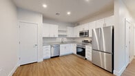 Located at 8749 Waterton Rd in Littleton, Colorado, this single-floor, 2-bedroom, 1-bathroom home offers a clean, modern design with thoughtful finishes throughout. The kitchen is a standout feature, showcasing crisp white shaker cabinets, granite-style countertops, and a full suite of stainless steel appliances including a refrigerator, range, microwave, and dishwasher — all set atop warm, wood-style luxury vinyl flooring. The open layout connects the kitchen to the living room, which is bright and airy, highlighted by natural light streaming through windows with blinds and the same durable flooring continuing throughout. Both bedrooms are comfortably sized, with the primary bedroom offering generous proportions, plush carpeting, and ample closet space — including walk-in closets with wire shelving systems. The full bathroom is well-appointed with white cabinetry, granite countertops, a tub-shower combo with tile surround, and matching wood-style flooring. Additional practical spaces include a dedicated laundry room and utility room. The home's neutral color palette and modern finishes create a fresh, move-in-ready atmosphere throughout.
