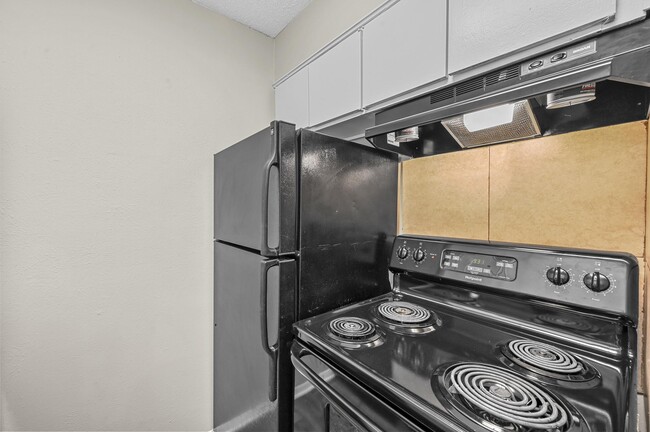 Updated kitchen with black appliances - Finley Square Apartments