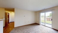 Located at 1237 Watermark Dr in Lancaster, Ohio, this single-floor residence offers two bedrooms and two bathrooms within a practical and efficiently arranged floor plan. The galley-style kitchen features warm wood-toned cabinetry with white accents, laminate hardwood flooring, a double-basin sink, and white appliances including a range and refrigerator, with ample counter and cabinet storage along both sides. The living room is carpeted and bathed in natural light through a sliding glass patio door that opens to an outdoor view, creating a bright and welcoming atmosphere. A second sliding glass door is also present, reinforcing the connection to the outdoors. Both bedrooms are carpeted and feature windows with blinds that allow for natural light and privacy. The primary bedroom offers a comfortable footprint suited for standard furnishings. The two bathrooms include one with hardwood-style flooring, a vanity with sink, toilet, and a shower-tub combination, and a second bathroom featuring a clean, white walk-in shower stall. Neutral wall tones and textured ceilings are consistent throughout, giving the space a cohesive and move-in-ready appearance. Wood-trimmed interior doors and warm baseboards add a touch of traditional character throughout the home.