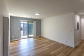 Located at 2520 College Ave in Berkeley, CA, this thoughtfully designed 3-bedroom, 2-bathroom unit offers a clean, modern aesthetic throughout its single-floor layout. Light hardwood flooring flows seamlessly across all living areas, complementing the bright white walls and contemporary finishes.

The open-concept kitchen and living area serves as the heart of the unit. The kitchen features sleek, high-gloss white cabinetry, stainless steel appliances including a refrigerator, range, and dishwasher, and a striking marble-look quartz countertop. The adjoining living room is generously proportioned and opens directly to an outdoor area through a sliding glass door, filling the space with natural light.

Each of the three bedrooms is appointed with hardwood floors, white walls, and sliding closet doors offering built-in storage. The primary bedroom is a comfortable size, while additional bedrooms are well-suited for various uses. Bedrooms feature windows with views of surrounding greenery.

The two bathrooms maintain the unit's modern sensibility, with one featuring a wall-mounted vanity with a mirrored medicine cabinet and large-format dark tile flooring, and the other showcasing a walk-in shower with floor-to-ceiling white tile and a mosaic tile floor. A connecting hallway ties all rooms together efficiently.