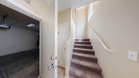 Located at 5870 Barbosa Dr in North Las Vegas, NV, this multi-floor home offers 2 bedrooms, 3 bathrooms, and a well-organized layout spread across three levels. The ground level houses a private garage with an automatic opener, concrete flooring, and an included water heater, along with a tiled entryway that leads to carpeted stairs connecting the upper floors. The main living level features a kitchen equipped with warm oak cabinetry, granite-toned countertops, a gas range, built-in microwave, and light tile flooring throughout. Adjacent cabinetry provides additional storage, and a nearby hallway connects to the staircase. The upper level contains both bedrooms, each featuring plush carpet flooring and ceiling fans. The spacious primary bedroom includes a walk-in closet, a sliding glass door that opens to an outdoor view, and an additional window that fills the room with natural light. The secondary bedroom also offers a closet and a bright window with exterior views. Three bathrooms serve the home, including one with a full soaking tub and shower combo and another with wood-look vinyl flooring. With two closets and a practical multi-level design, this home delivers comfortable, functional living in a well-structured layout.