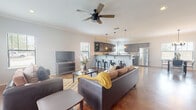 Located at 3405 Treeline Dr in College Station, Texas, this single-story home offers a well-designed open-concept layout that seamlessly connects the living, dining, and kitchen areas. Polished concrete floors flow throughout, lending a contemporary, low-maintenance aesthetic to the entire space.

The living room is bright and welcoming, with multiple windows allowing generous natural light to filter in. Crown molding, recessed lighting, and a ceiling fan with wood-tone blades add both comfort and style to the room.

The kitchen is a standout feature, equipped with gray beadboard-style cabinetry, dark countertops, a classic white subway tile backsplash, and a full suite of stainless steel appliances including a refrigerator, range, microwave, and dishwasher. A peninsula with bar seating bridges the kitchen and living area, making it ideal for casual dining or entertaining.

The dining area is defined by an elegant chandelier and large windows that frame neighborhood views, creating a bright and inviting atmosphere for meals. The space accommodates a round dining table with ample room to move freely.

Overall, the home presents a cohesive, modern design with neutral tones, thoughtful finishes, and an efficient layout well-suited to everyday living.